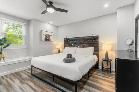 a bedroom with a bed and a dresser with wooden floor