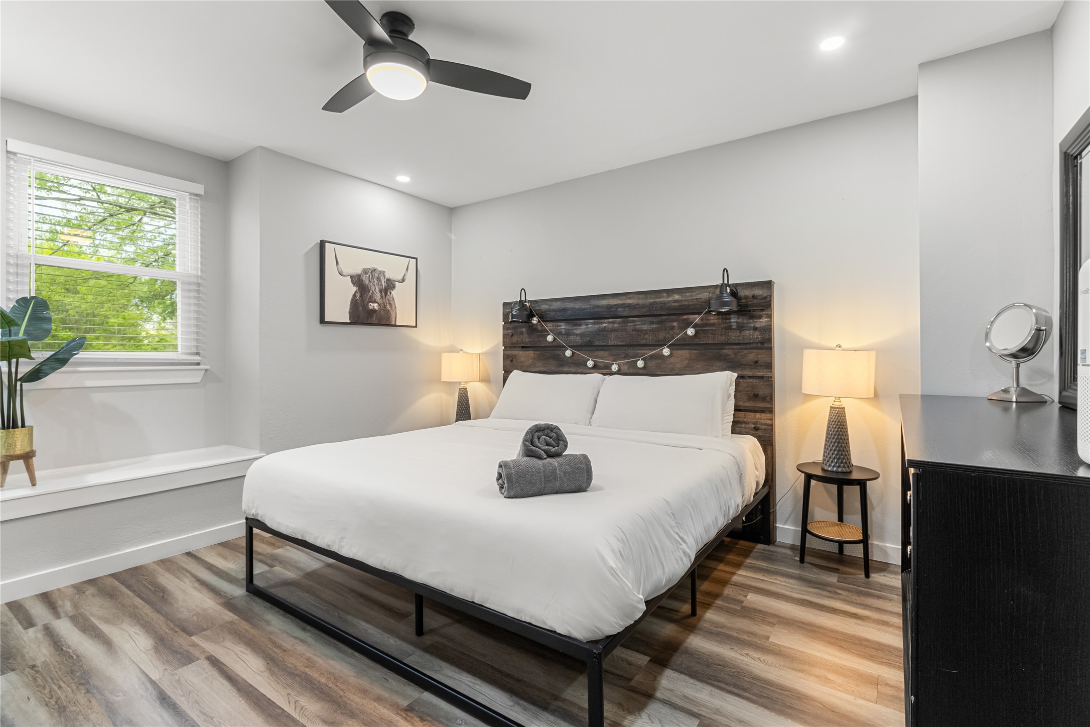 5405 Meadow Crest Austin, TX 78744 - Photo 15 of 33 a bedroom with a bed and a dresser with wooden floor