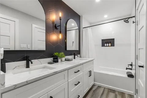 a bathroom with a sink a large mirror and shower