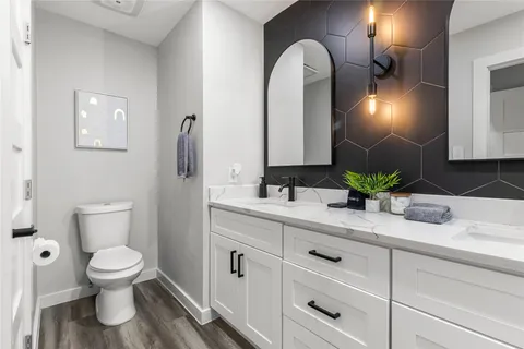 a bathroom with a toilet sink and mirror