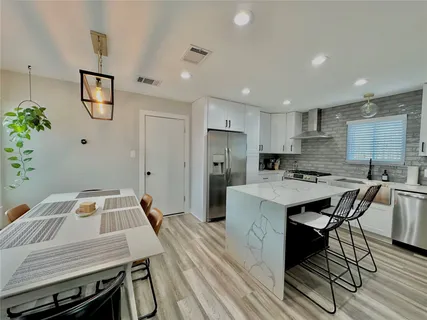 a kitchen with a table chairs refrigerator and microwave