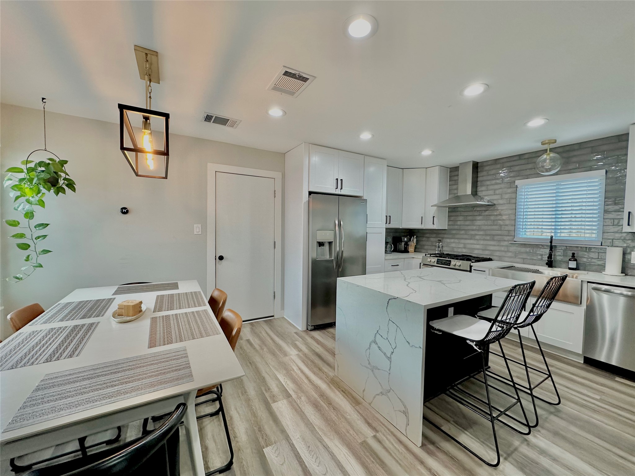 5405 Meadow Crest Austin, TX 78744 - Photo 10 of 33 a kitchen with a table chairs refrigerator and microwave