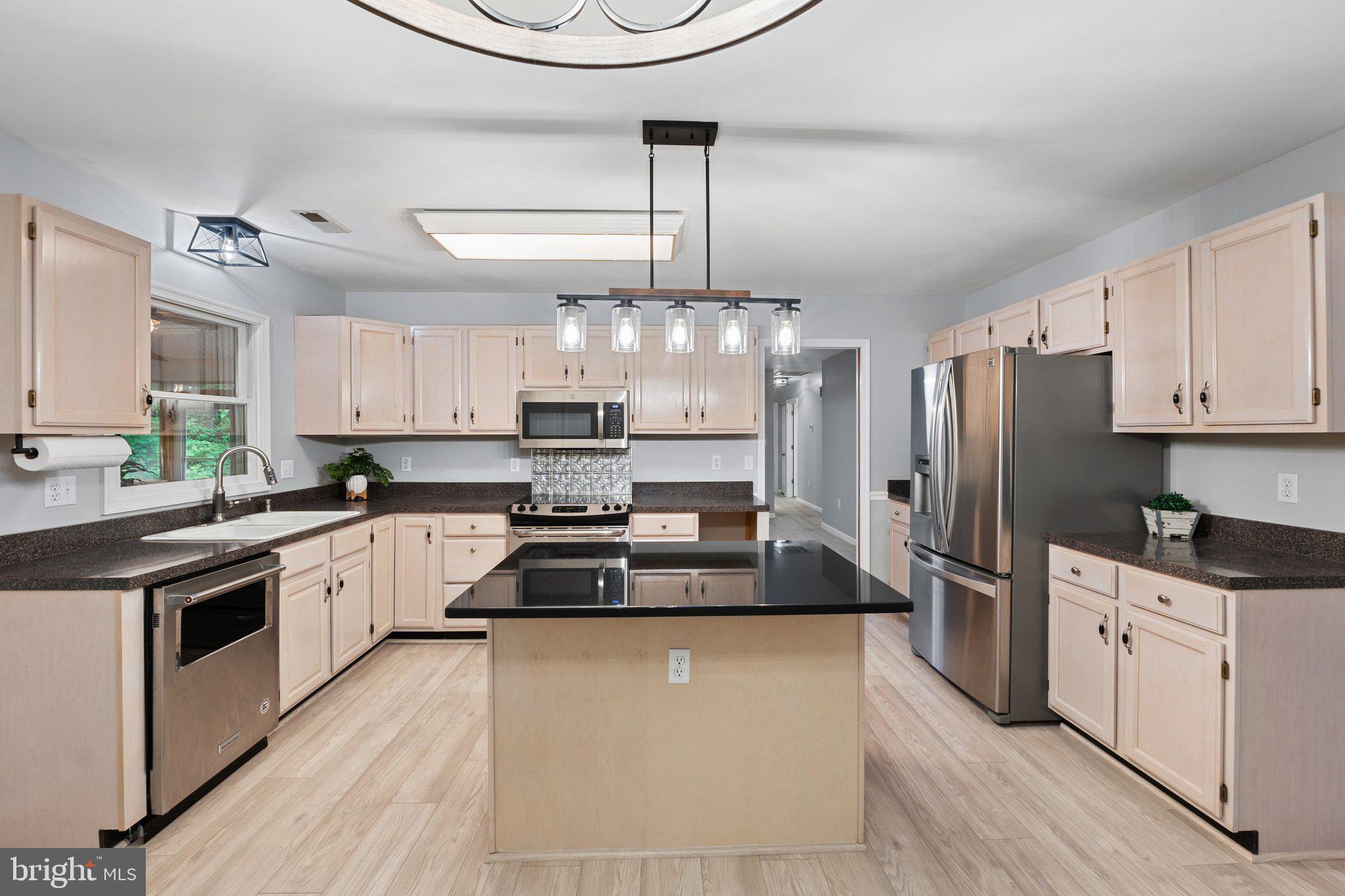 a kitchen with stainless steel appliances a stove a refrigerator and white cabinets