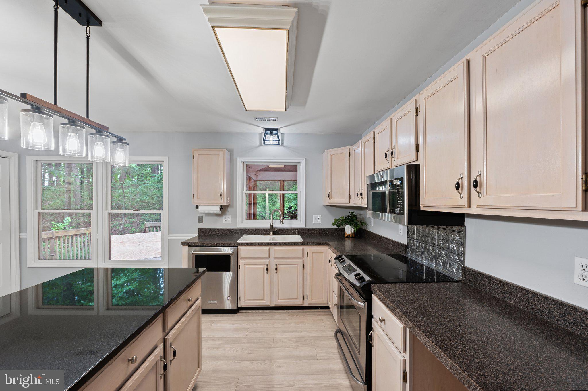 1420 Fishel Road Winchester, VA 22602 - Photo 10 of 34 a kitchen with stainless steel appliances granite countertop a sink a stove top oven a counter space and cabinets