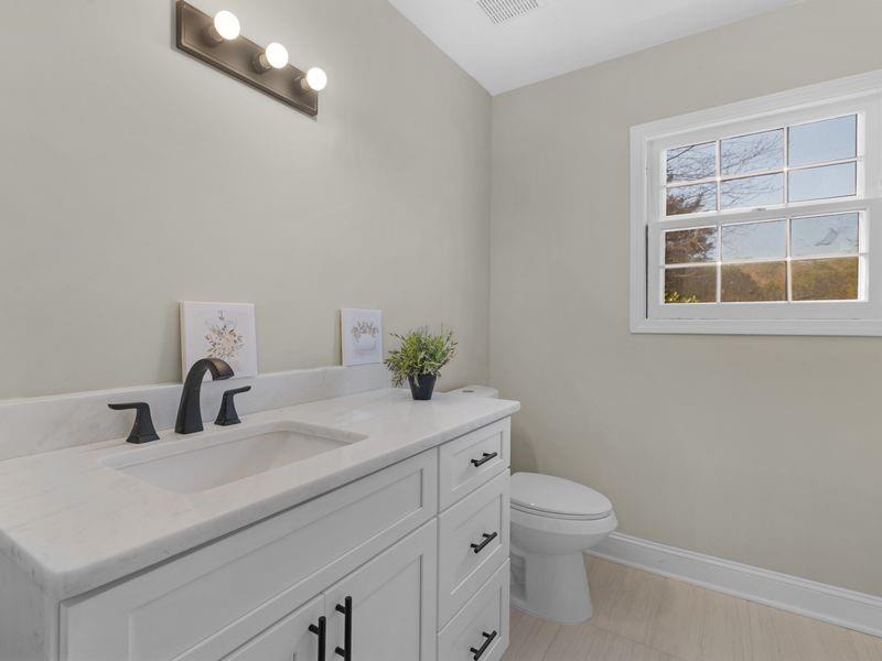 9300 Floyd Road Jonesboro, GA 30236 - Photo 22 of 34 a bathroom with a toilet a sink and mirror