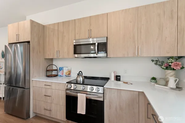 a kitchen with stainless steel appliances white cabinets and a refrigerator