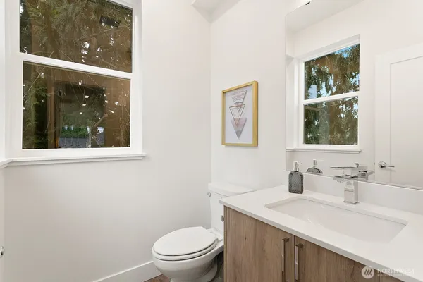 a bathroom with a sink a toilet and a window