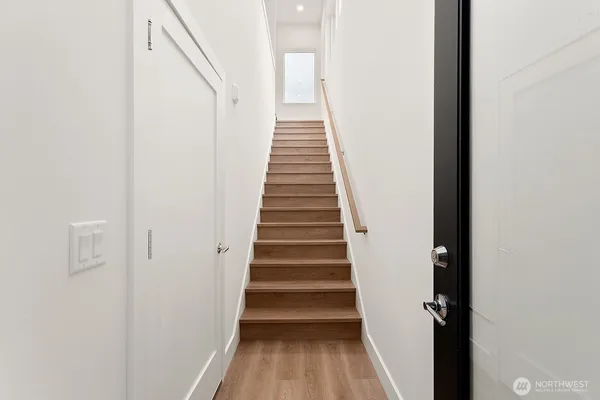 a view of a hallway with wooden floor and entryway