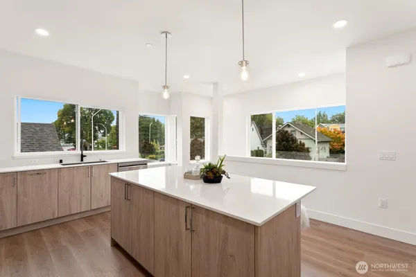 a kitchen with stainless steel appliances a large window and cabinets