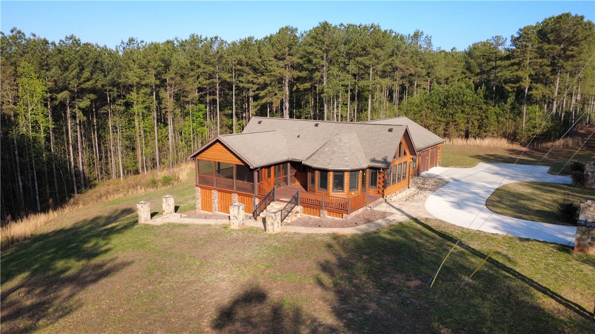 128 McAlister Road West Union, SC 29696 - Photo 38 of 40 A secluded lodge-style residence nestled among a dense forest, offering a tranquil retreat with a sweeping circular driveway.