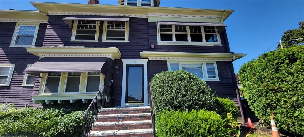 88 Corey Street, Unit 2 Boston, MA 02132 - Photo 1 of 23 a front view of a building with a garden