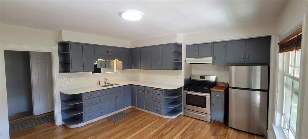 88 Corey Street, Unit 2 Boston, MA 02132 - Photo 6 of 23 a kitchen with a refrigerator sink and cabinets