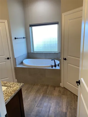 a bathroom with a bathtub and a window