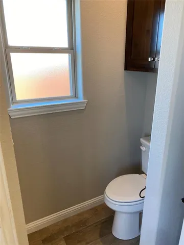 a white toilet sitting next to a window