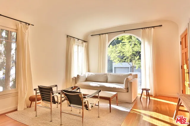 a living room with furniture and floor to ceiling windows