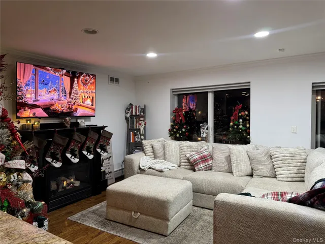 a living room with furniture a flat screen tv and a floor to ceiling window