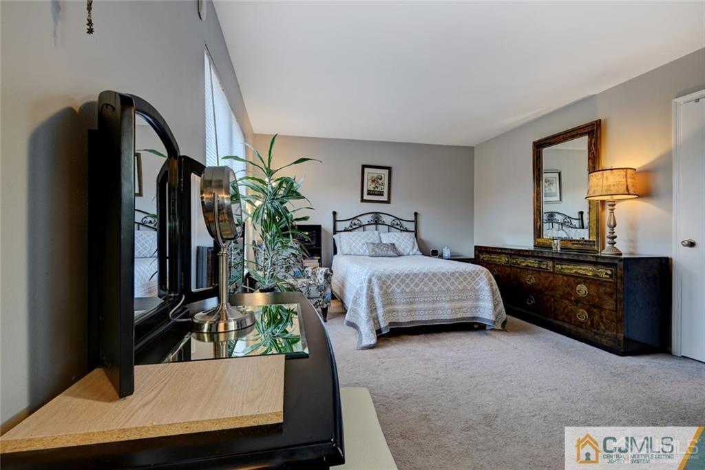360 Constitution Circle North Brunswick, NJ 08902 - Photo 14 of 21 a bedroom with a bed potted plant on dresser and a window