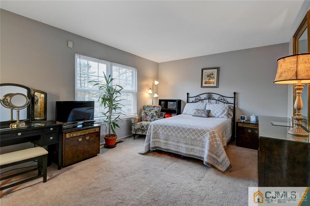 360 Constitution Circle North Brunswick, NJ 08902 - Photo 15 of 21 a bedroom with a bed a couch and a flat tv screen on dresser
