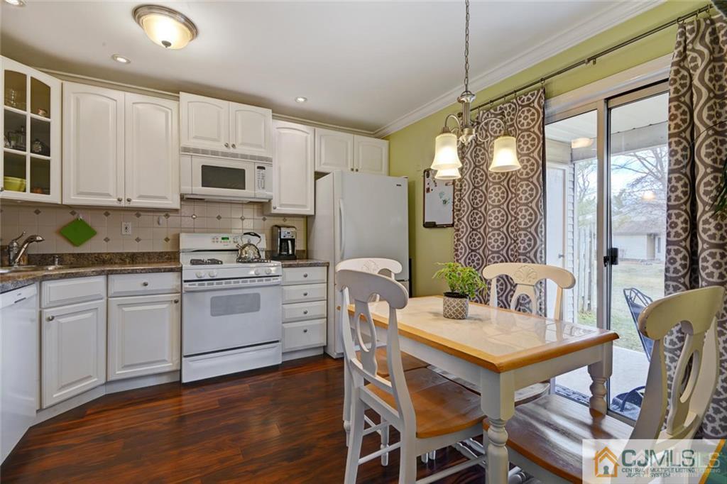 360 Constitution Circle North Brunswick, NJ 08902 - Photo 6 of 21 a kitchen with stainless steel appliances granite countertop a stove a refrigerator a kitchen island a table and chairs