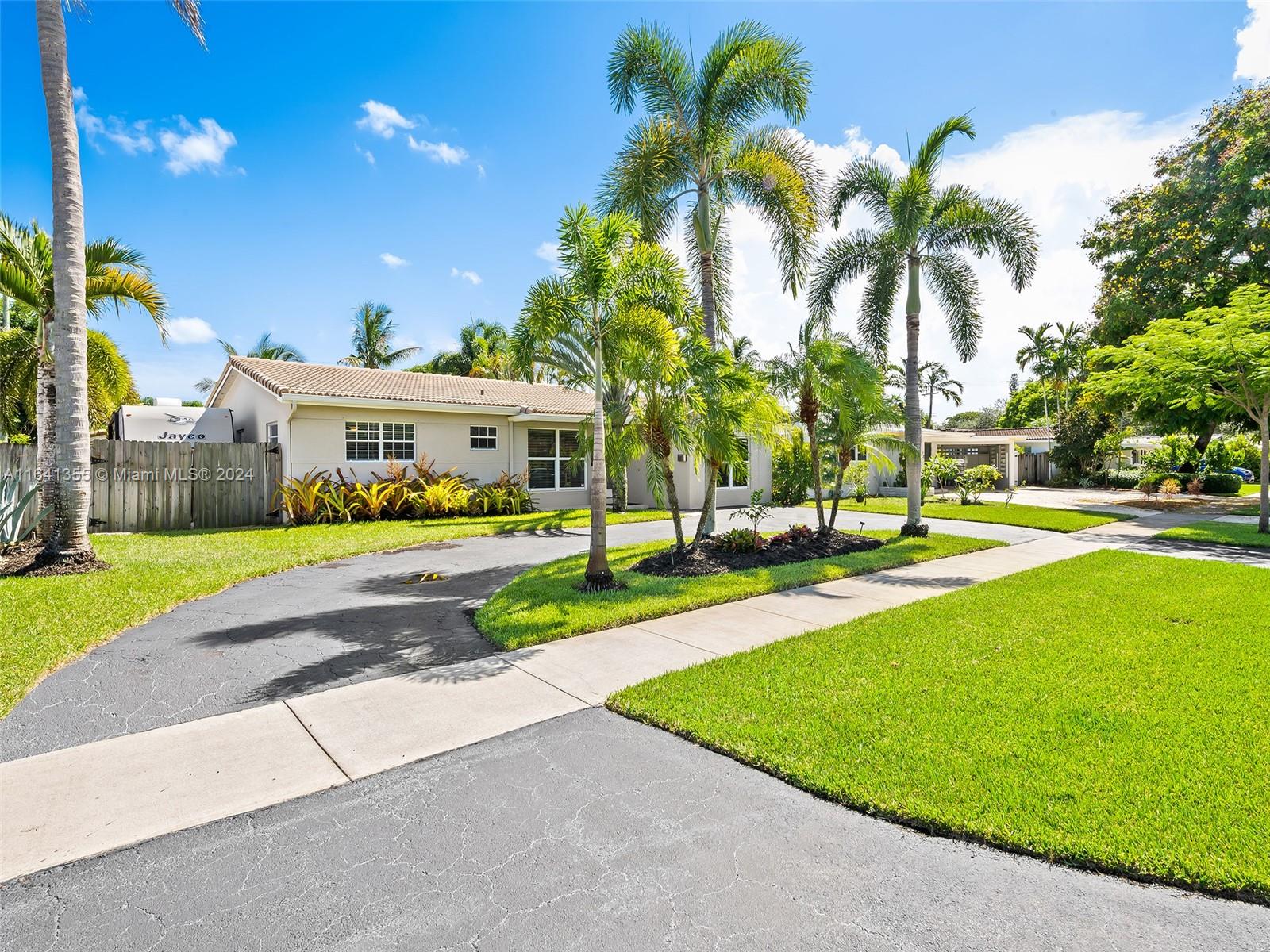 3904 Arthur Street Hollywood, FL 33021 - Photo 3 of 32 a view of a house with a yard and palm trees