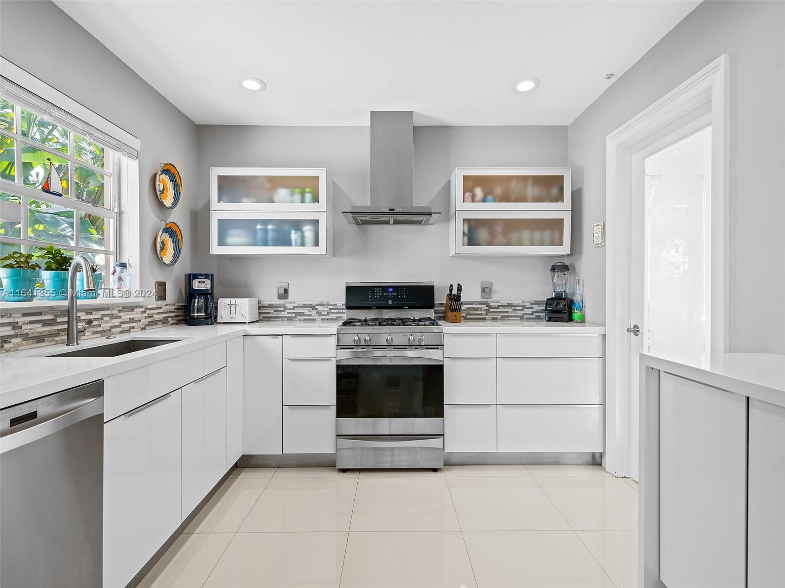 3904 Arthur Street Hollywood, FL 33021 - Photo 10 of 32 a kitchen with stainless steel appliances granite countertop white cabinets and window