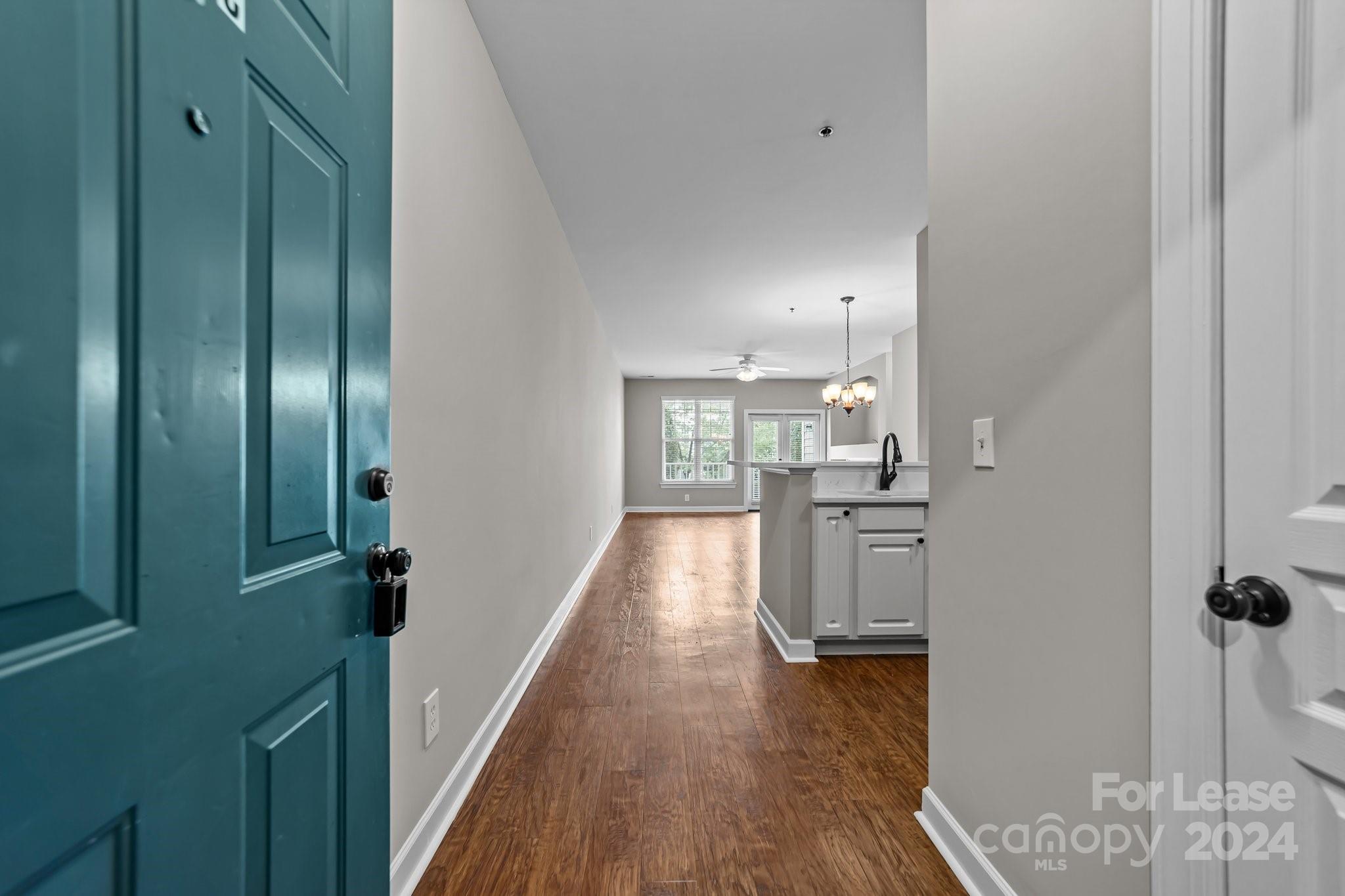 18605 Ruffner Drive, Unit 1C Cornelius, NC 28031 - Photo 3 of 27 a view of a hallway with wooden floor and cabinets