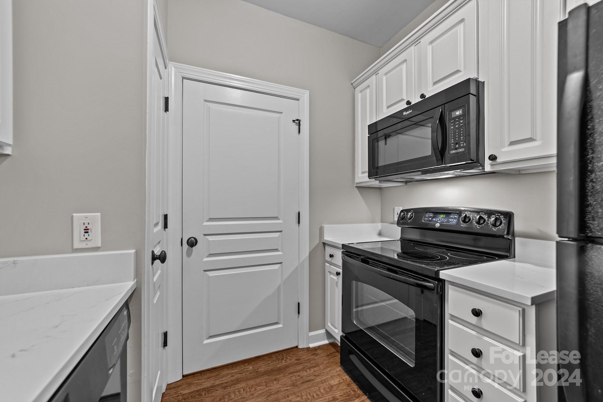 18605 Ruffner Drive, Unit 1C Cornelius, NC 28031 - Photo 9 of 27 a kitchen with white cabinets and stainless steel appliances