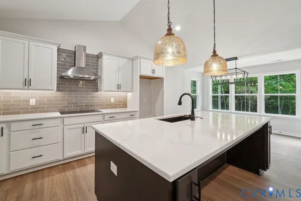 a kitchen with stainless steel appliances granite countertop a sink a stove and a wooden floors