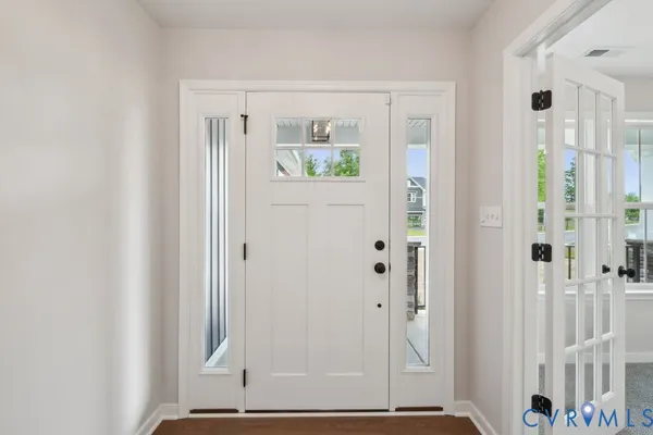 a view of a bedroom with wooden floor and door