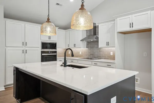 a kitchen with kitchen island a counter space a sink and a stove