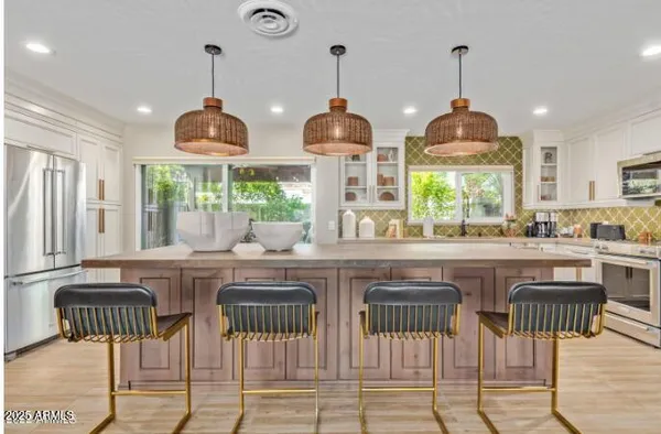 a kitchen with stainless steel appliances granite countertop wooden floor and refrigerator