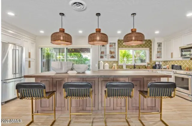 a kitchen with stainless steel appliances granite countertop wooden floor and refrigerator