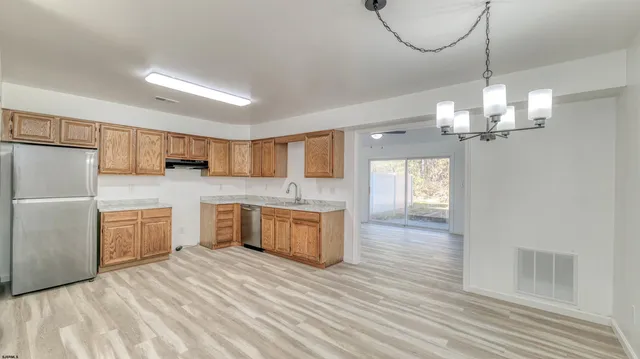 a view of a kitchen with a sink a refrigerator and a fireplace