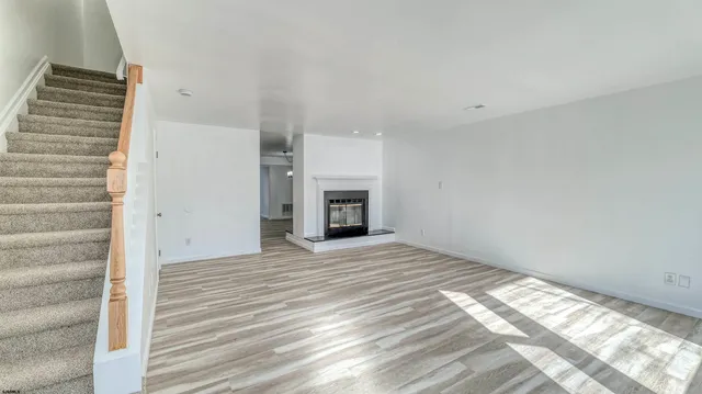 a view of an empty room with a fireplace and a window