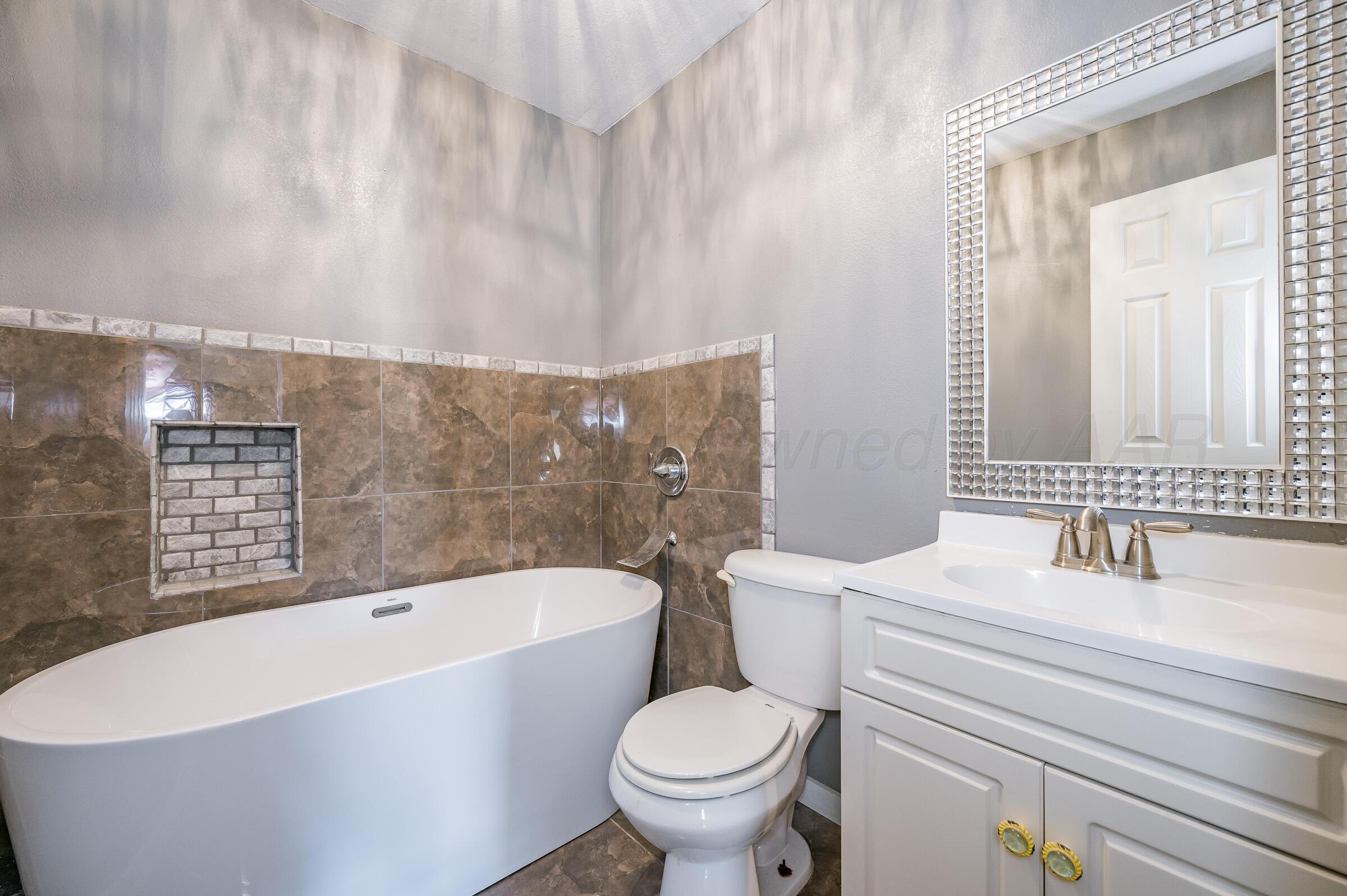 5336 Wheeler Lane Amarillo, TX 79110 - Photo 12 of 24 a bathroom with a sink a toilet and bathtub