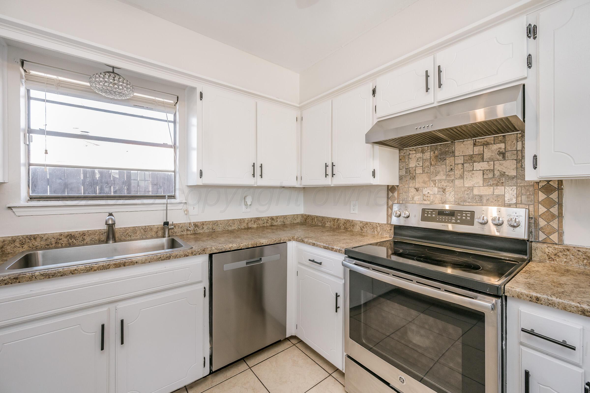 5336 Wheeler Lane Amarillo, TX 79110 - Photo 8 of 24 a kitchen with cabinets appliances a sink and a window
