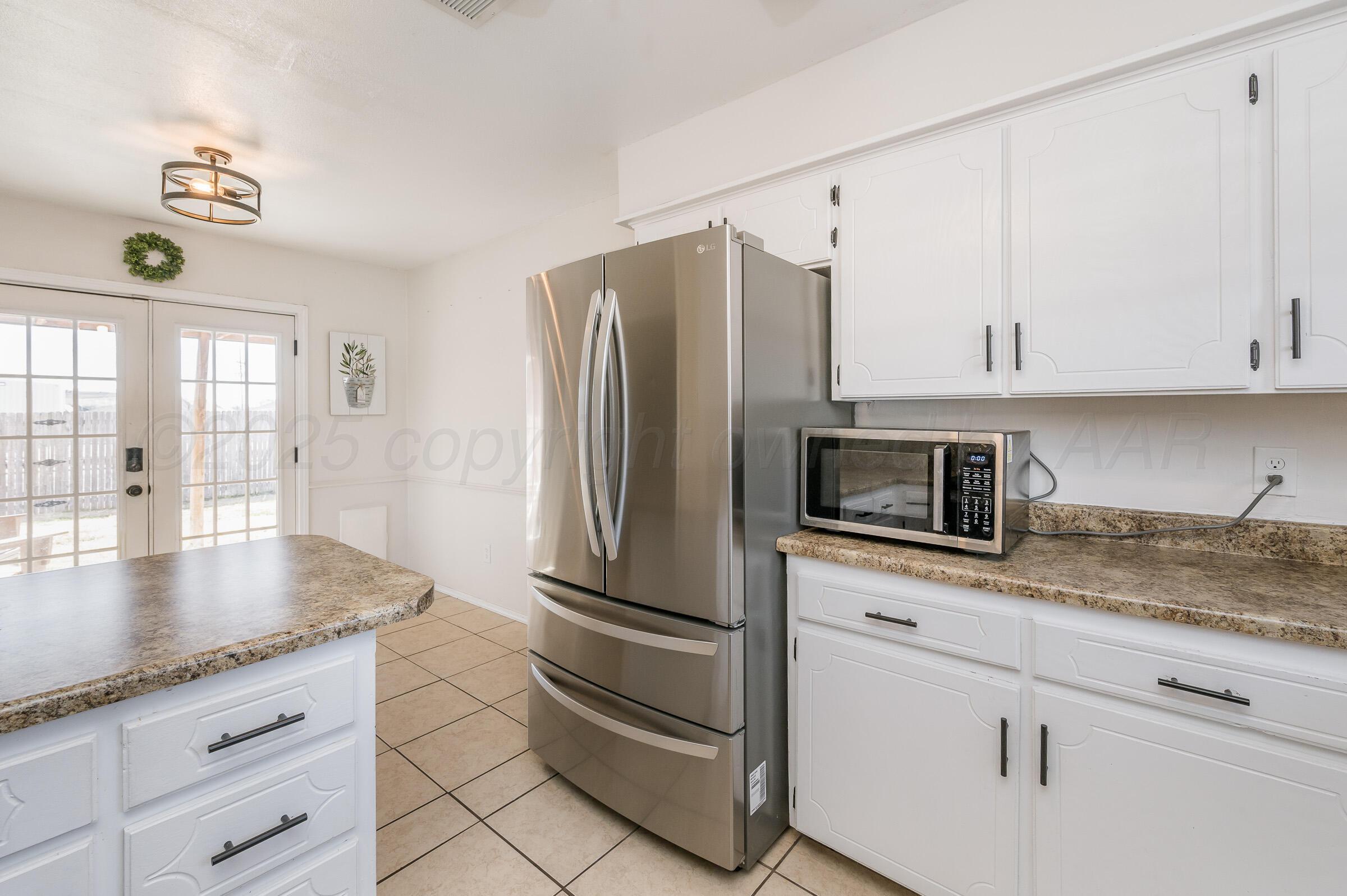 5336 Wheeler Lane Amarillo, TX 79110 - Photo 9 of 24 a kitchen with stainless steel appliances granite countertop a refrigerator a stove and a sink with granite countertops