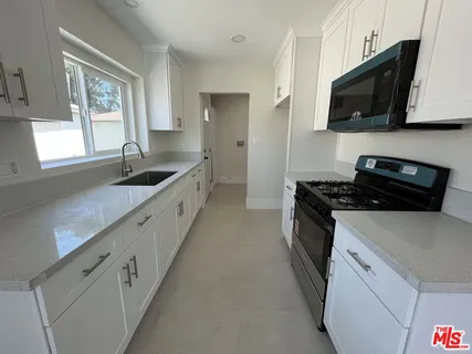 a kitchen with granite countertop a sink and a stove top oven