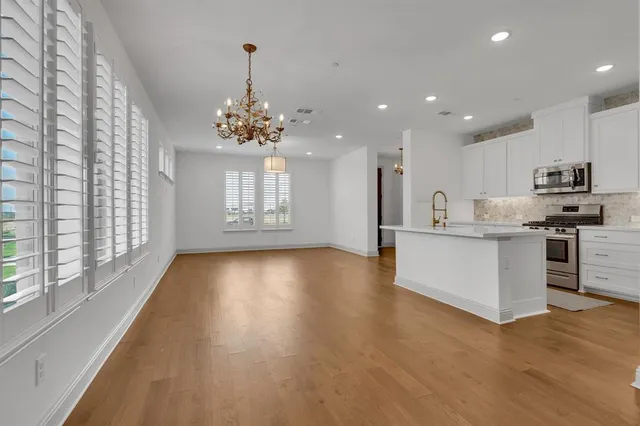 a view of a kitchen with granite countertop stainless steel appliances cabinets and a large window