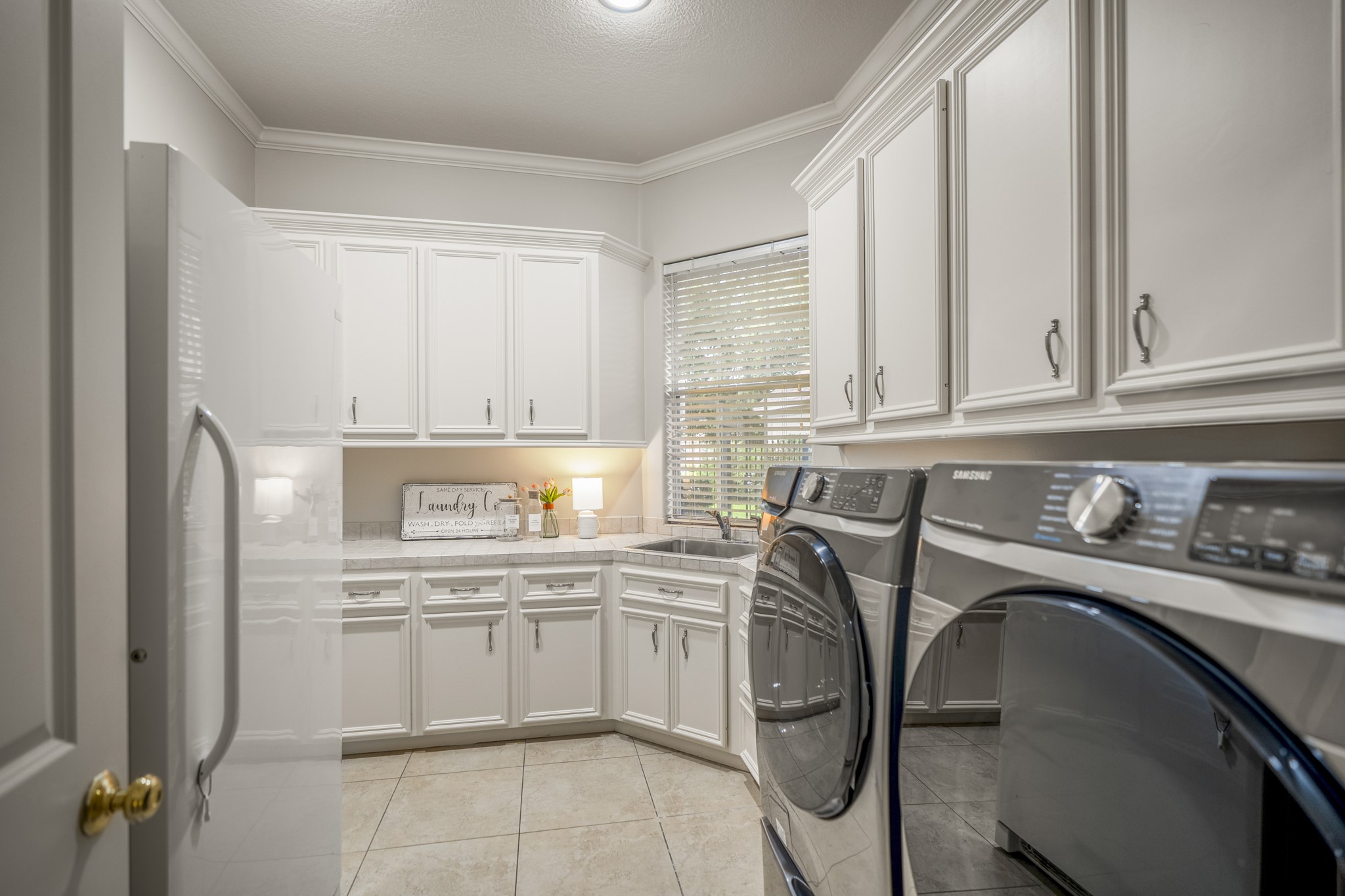 8806 Sterling Gate Circle Spring, TX 77379 - Photo 18 of 40 The laundry room is spacious with room for a second refrigerator and plenty of storage plus a sink.