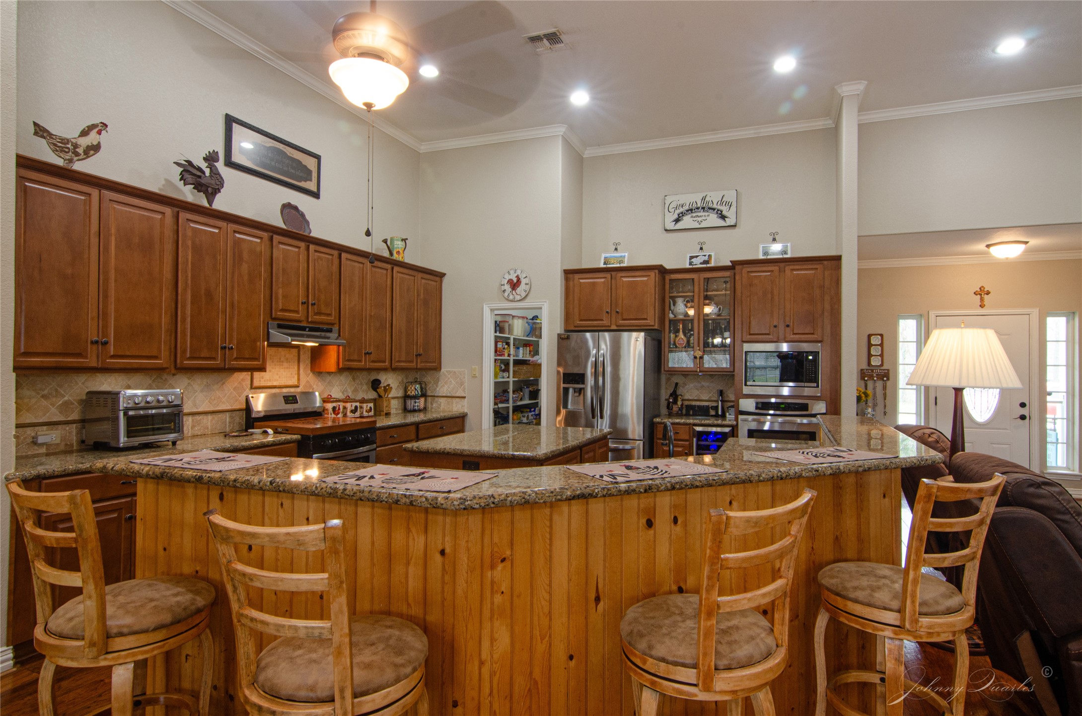 36606 Tejas Road Simonton, TX 77485 - Photo 14 of 32 a kitchen with stainless steel appliances kitchen island granite countertop a table chairs and a refrigerator