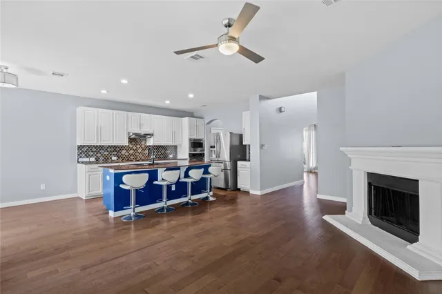 a living room with stainless steel appliances kitchen island granite countertop furniture and a fireplace