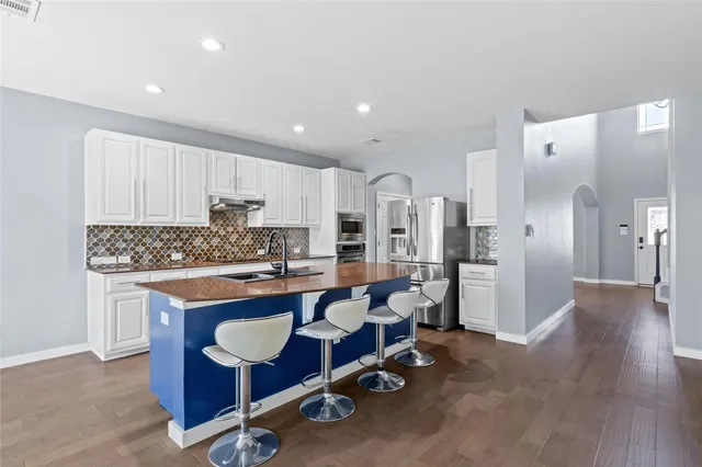 a kitchen with stainless steel appliances granite countertop a refrigerator and a stove top oven