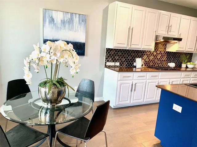 a kitchen with stainless steel appliances granite countertop a dining table chairs and a granite counter tops