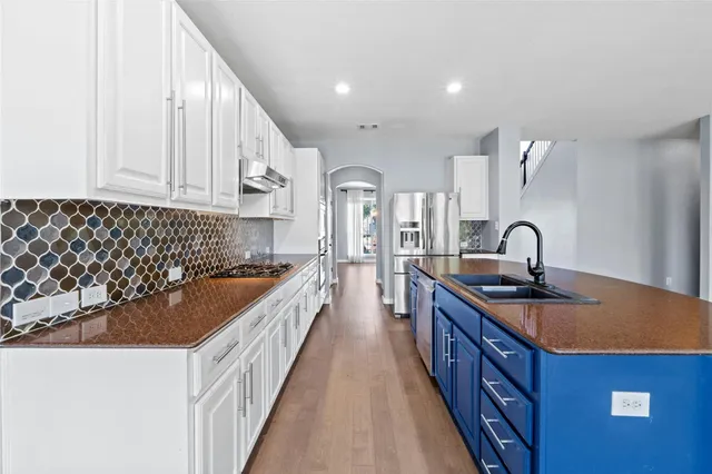 a kitchen with kitchen island a sink and a stove top oven
