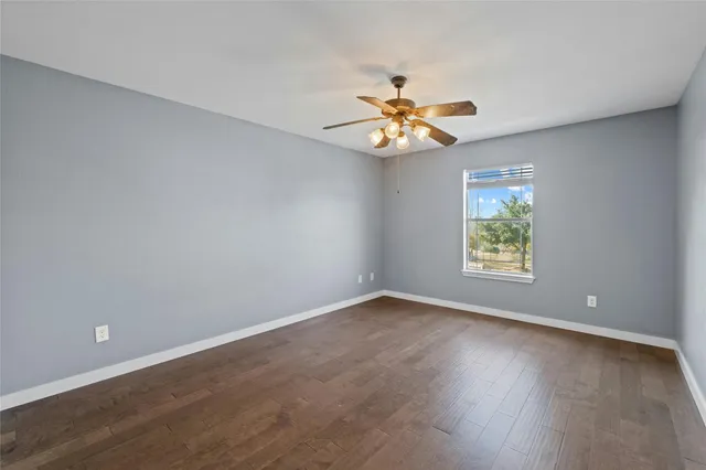 an empty room with a window and wooden floor
