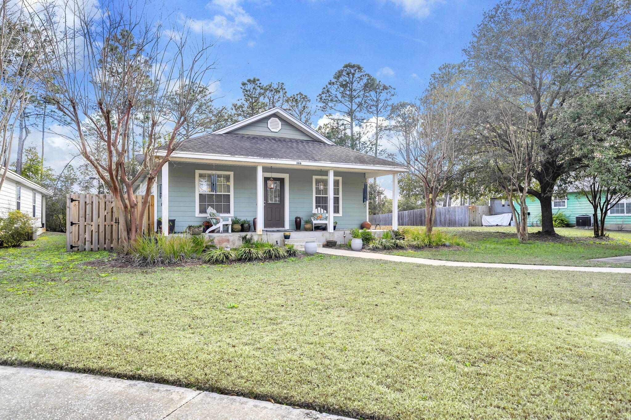 a view of a house with a yard and large tree