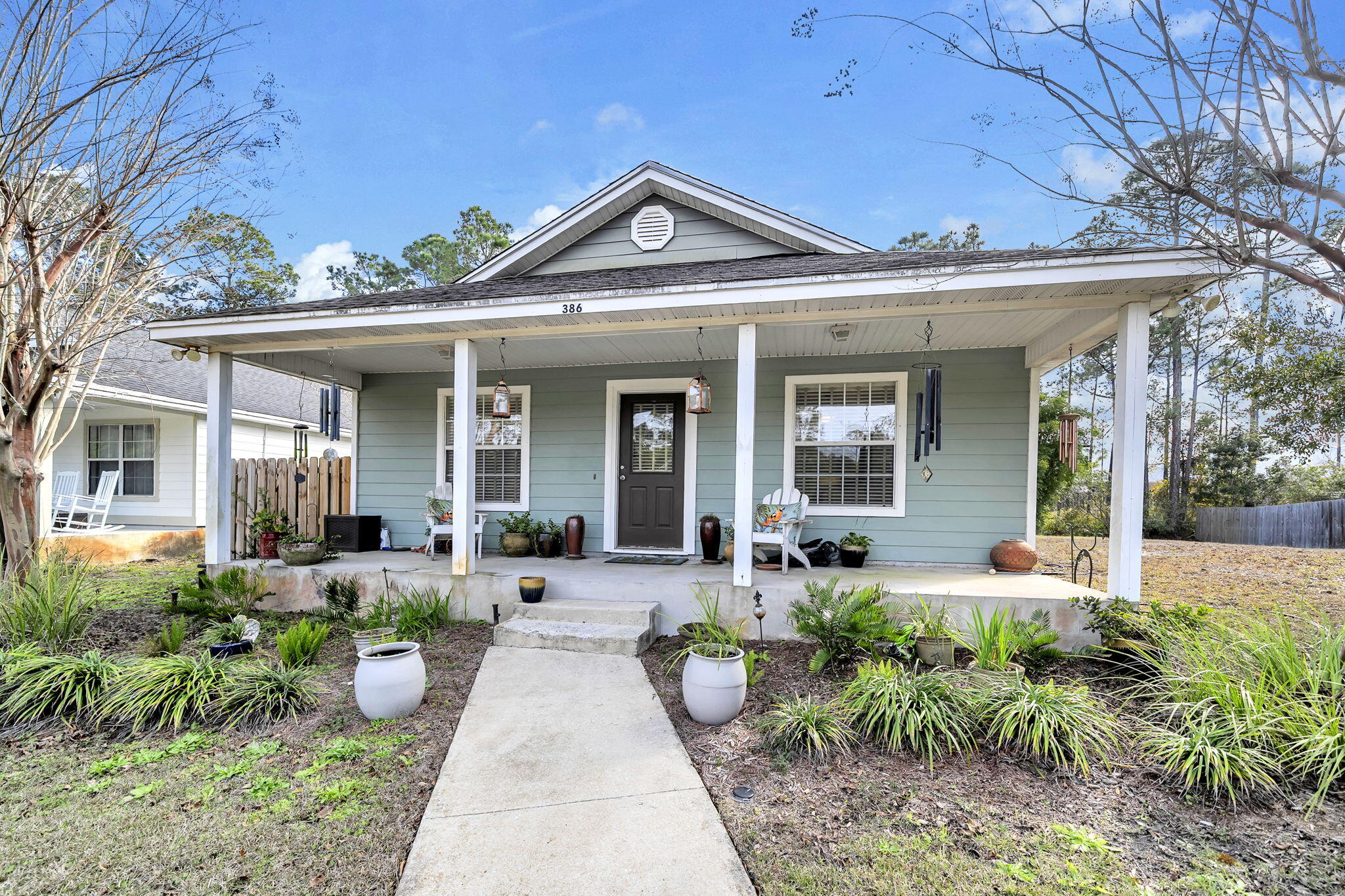 386 Hunters Road Santa Rosa Beach, FL 32459 - Photo 2 of 35 a front view of a house with sitting area and garden