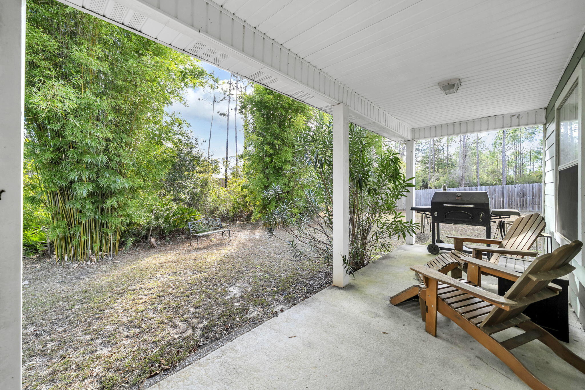 386 Hunters Road Santa Rosa Beach, FL 32459 - Photo 32 of 35 a view of a patio with table and chairs a barbeque grill with potted plants in front of door