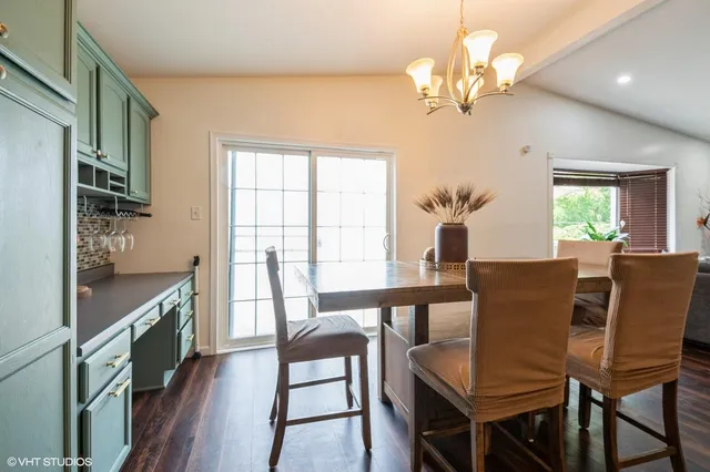 a view of a dining room with furniture a chandelier and a window